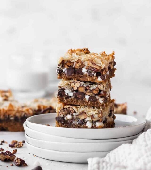 A stack of vegan magic bars on white plates.