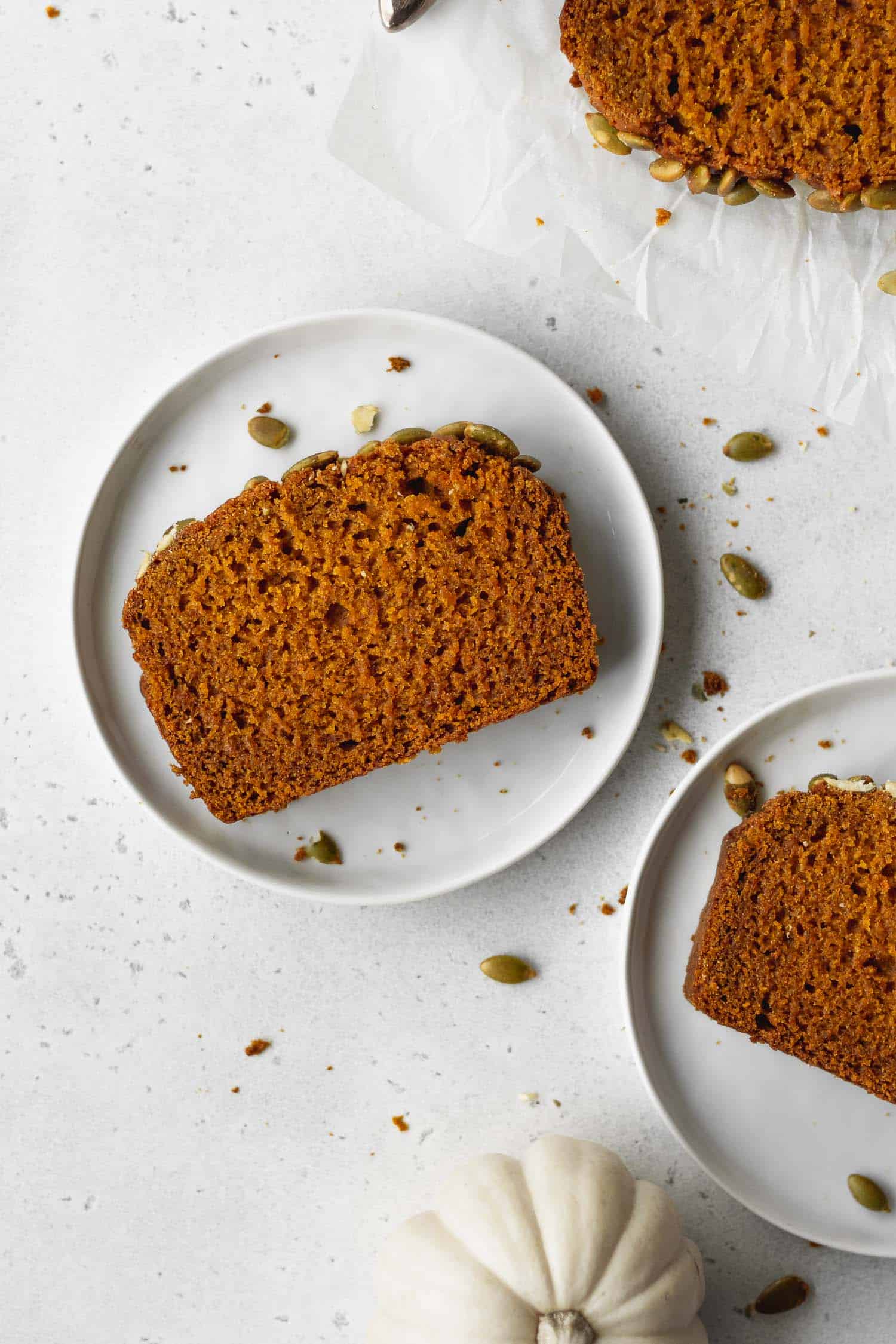 A slice of gluten free pumpkin bread on a white plate.