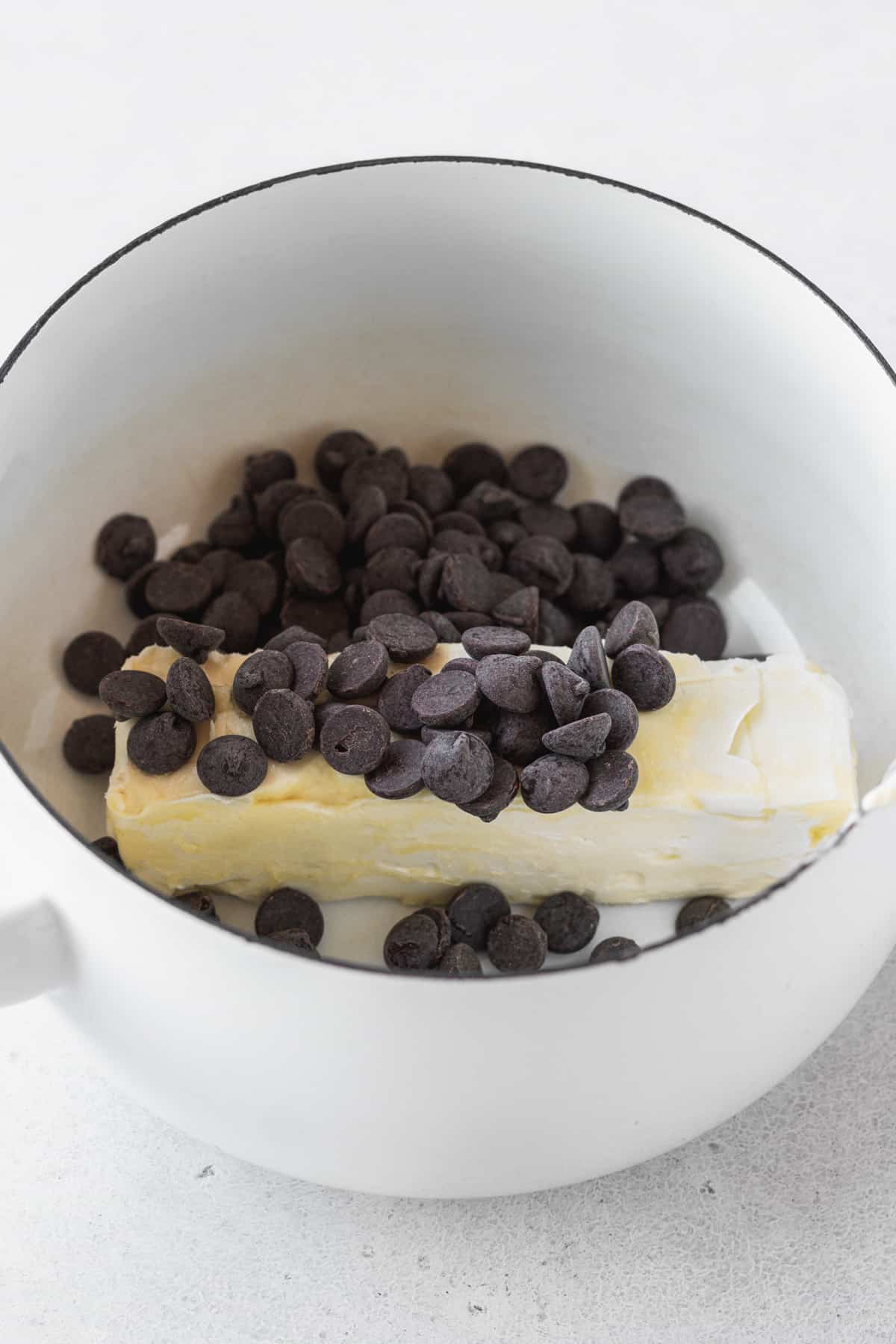 Butter & chocolate chips in a white enameled dutch oven.