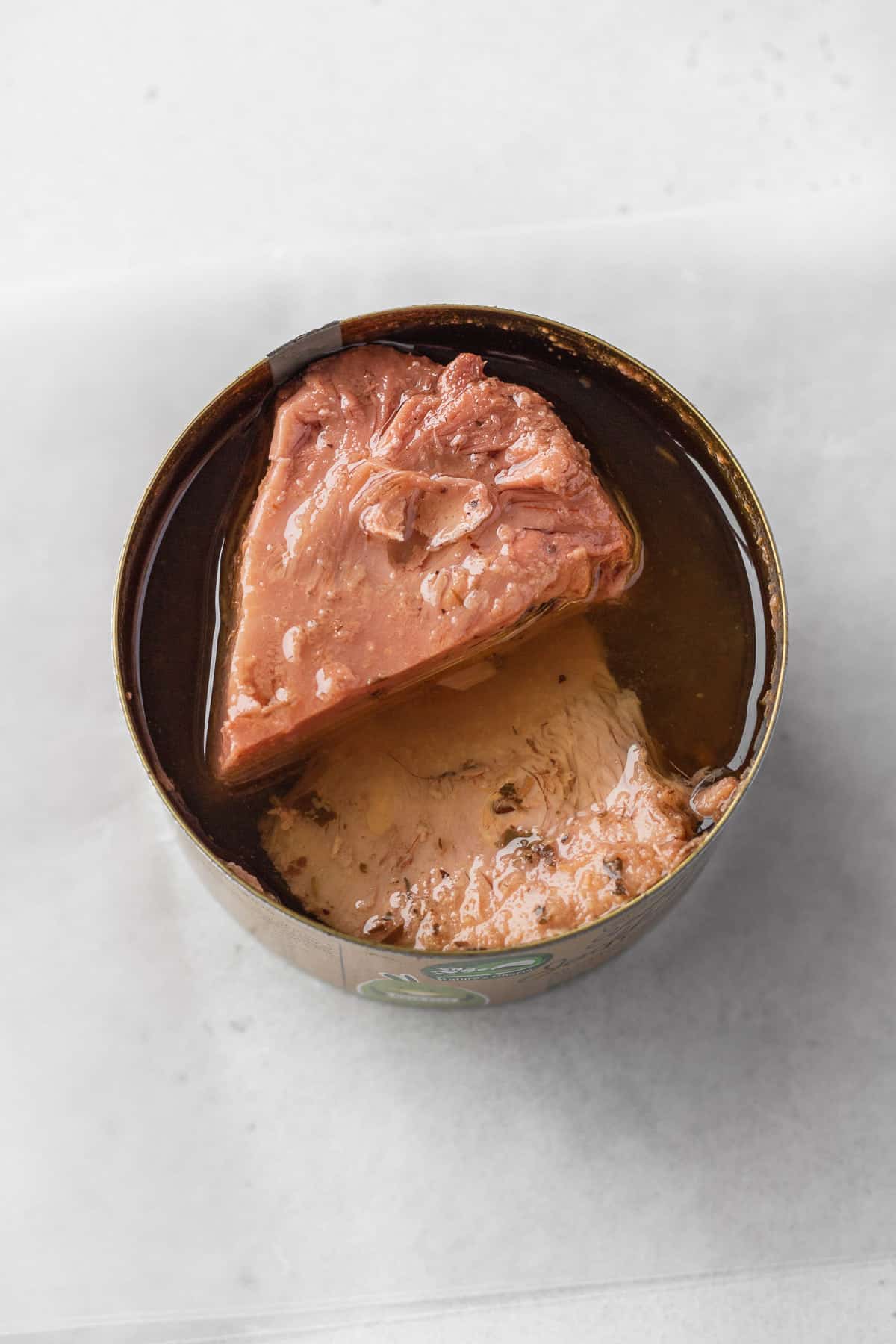 An opened can of young green jackfruit confit in oil.