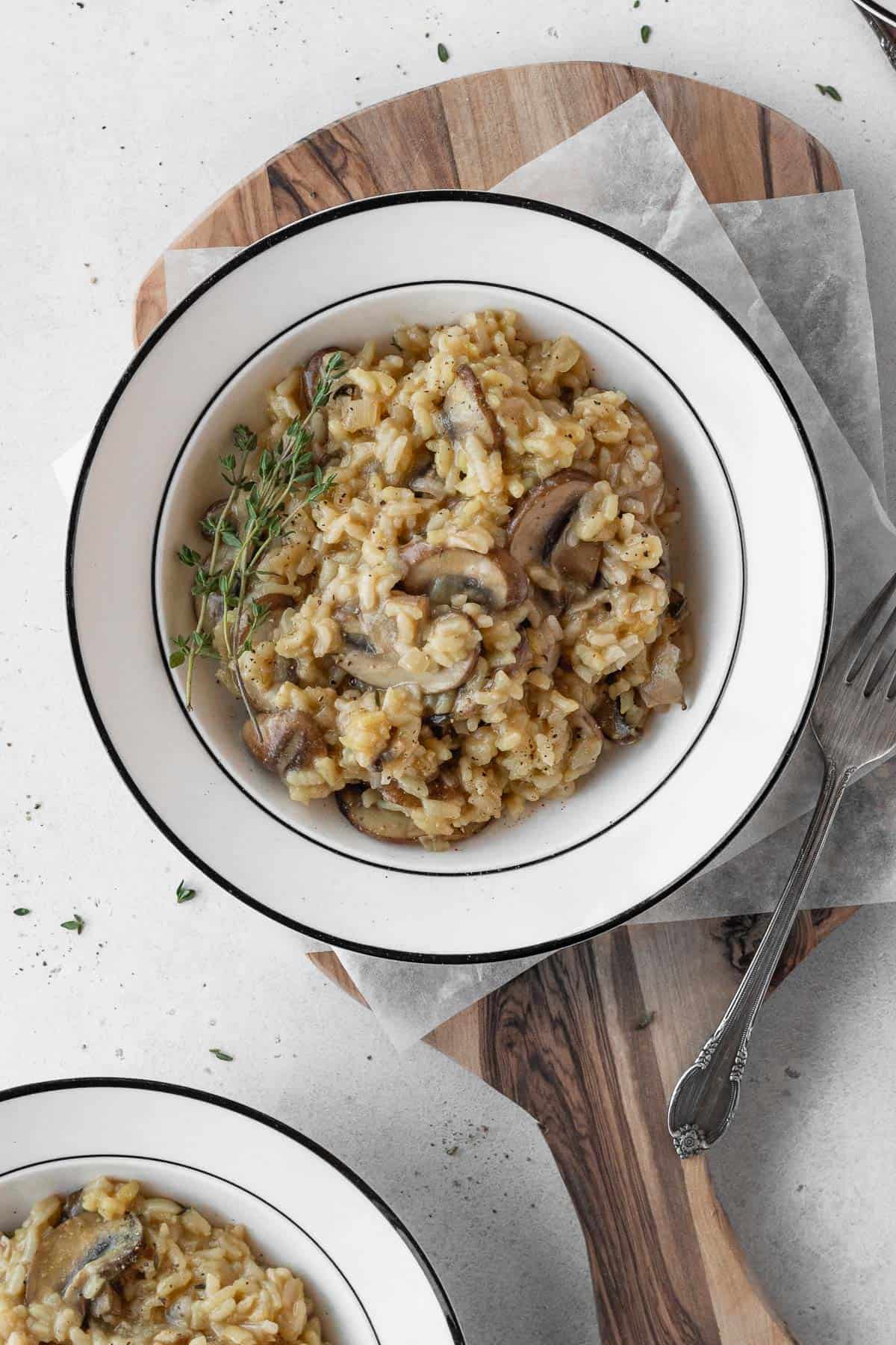 A white bowl of vegan risotto with mushrooms.
