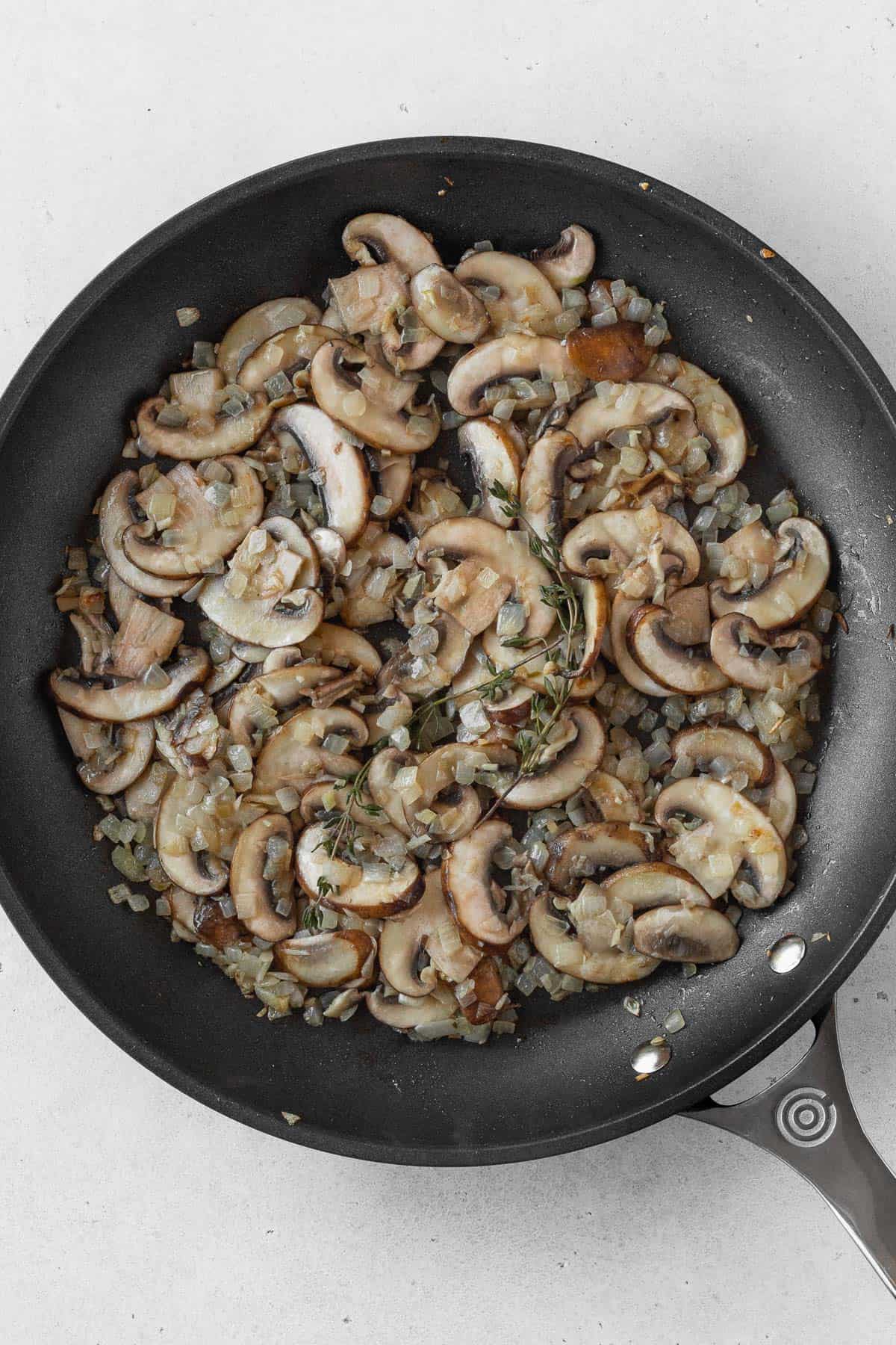 Add the mushrooms to the onions in the pan.