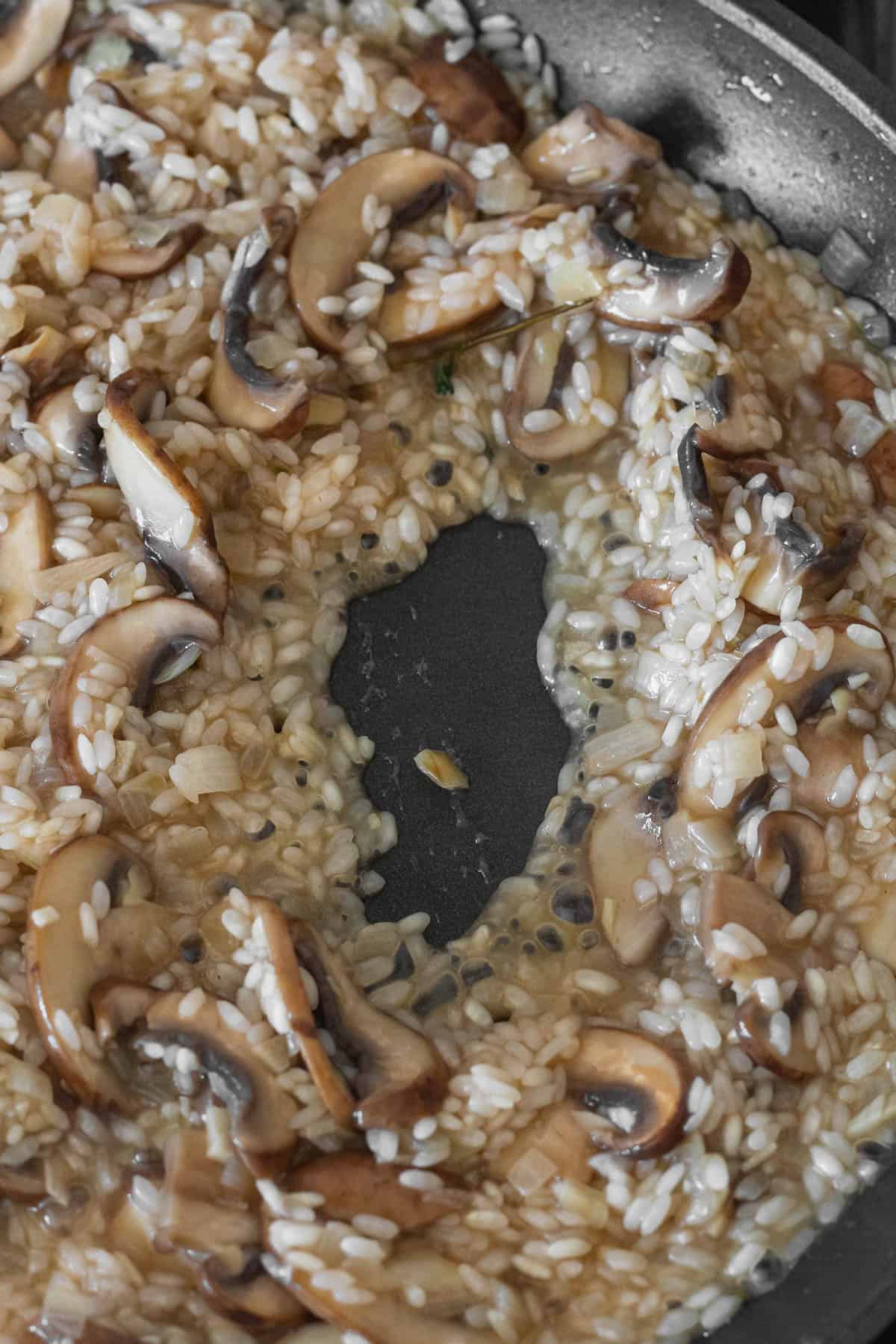 The rice absorbing stock in the pan.