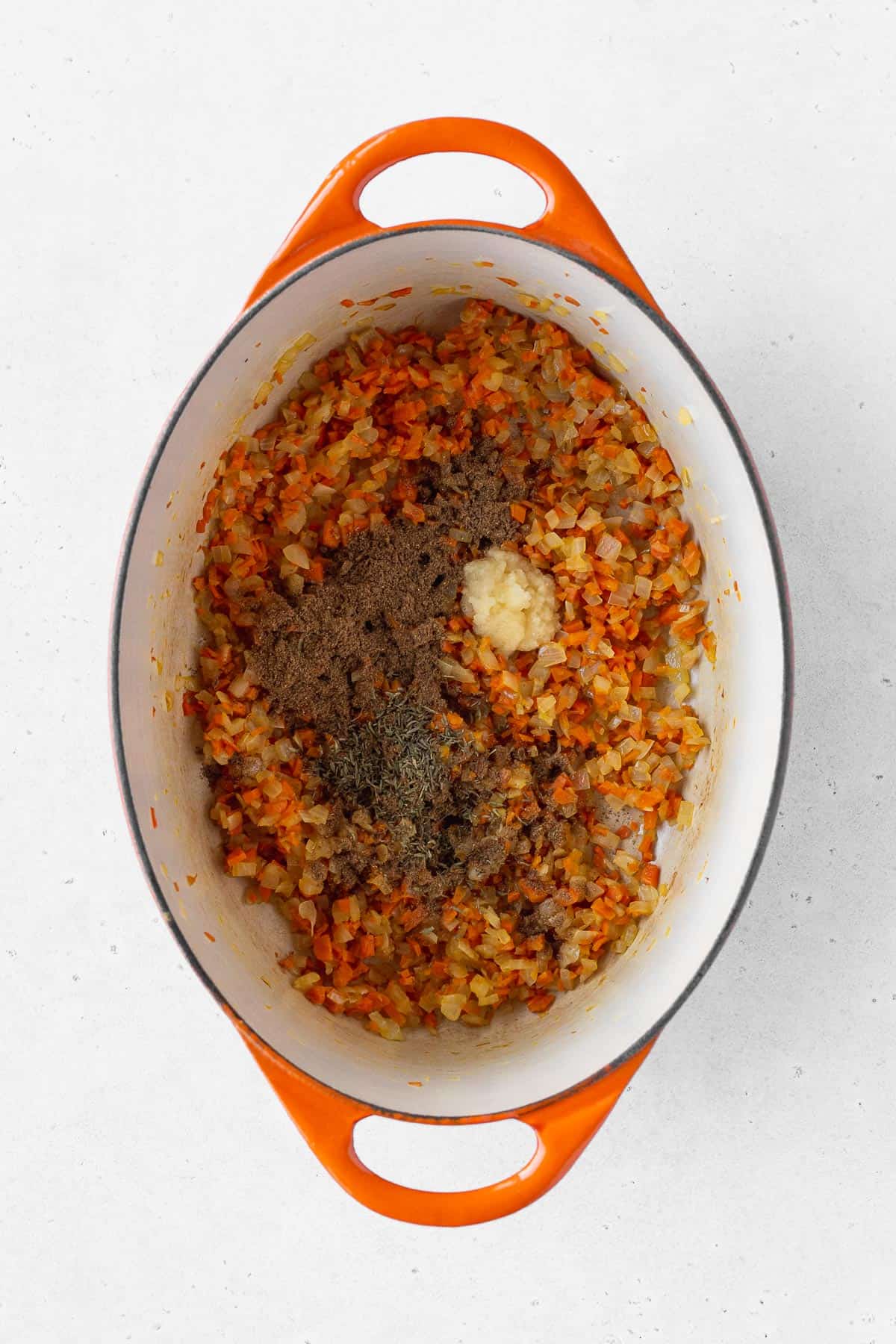 Garam masala, dried thyme, and grated garlic added to the pot.