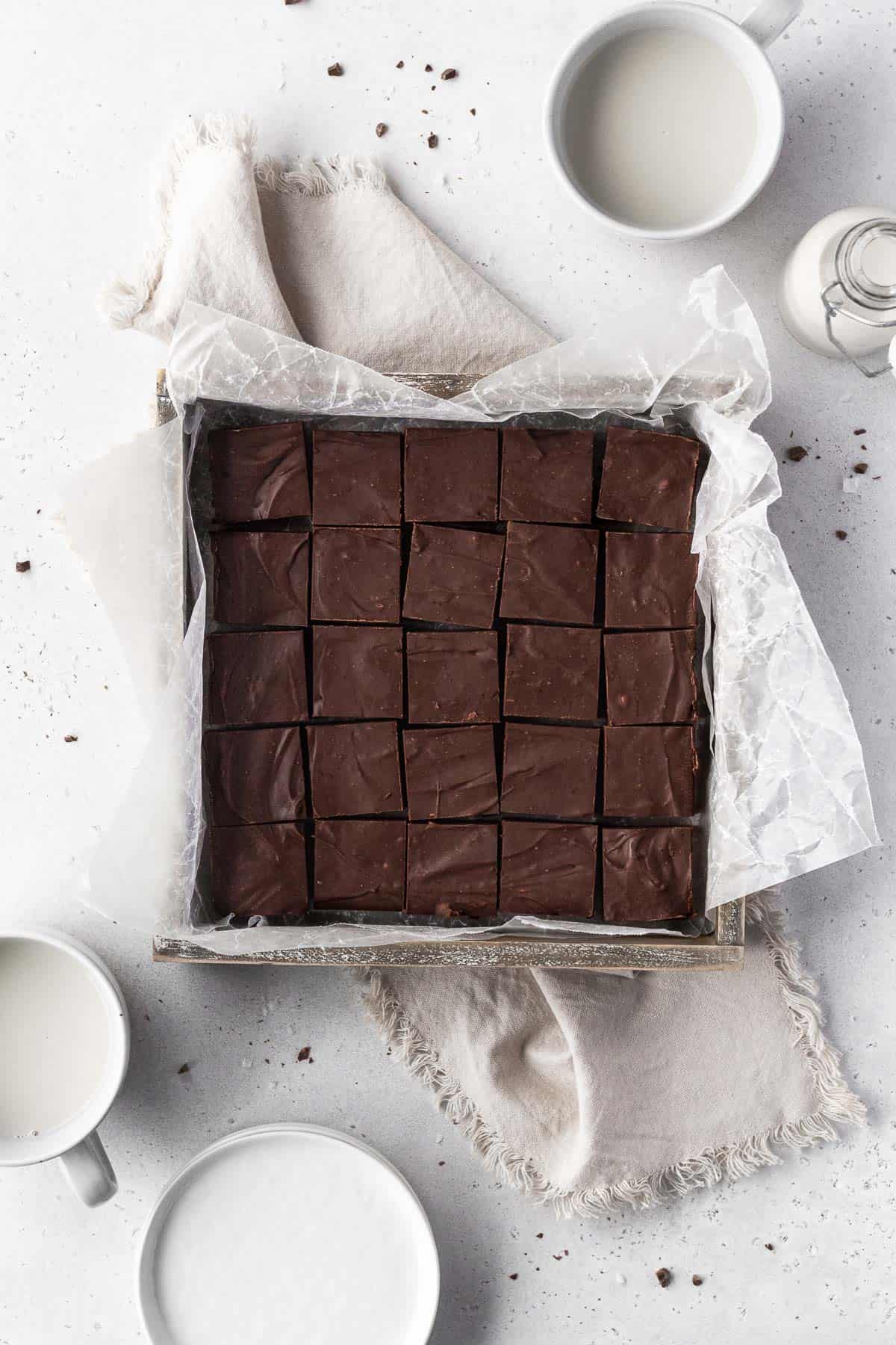 Overhead shot of square baking tin with a batch of dairy-free fudge cut into 20 squares.
