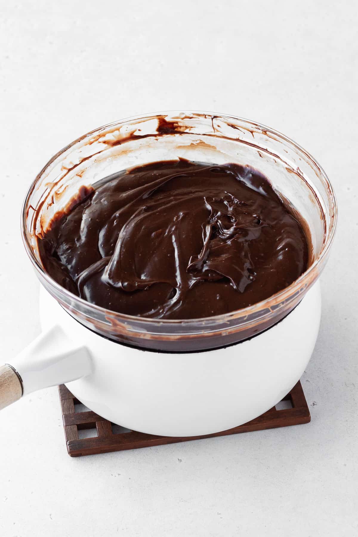 Fudge ingredients in a bowl on top of a double boiler after melting and being mixed.