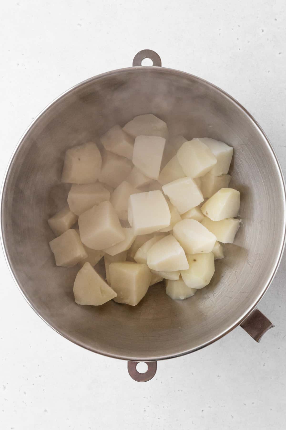 Drained potatoes in a mixing bowl.