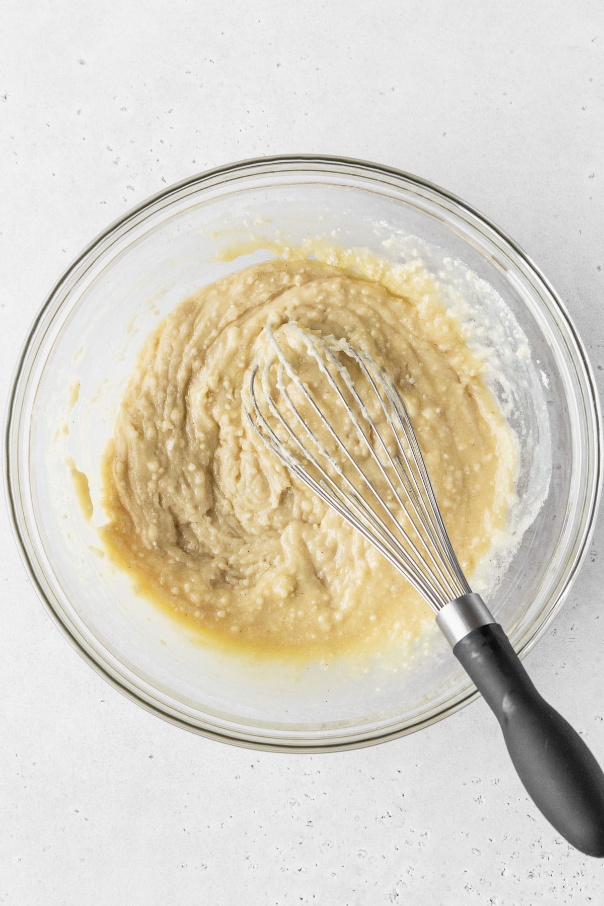 Dry ingredients added to wet ingredients for making dairy-free cupcakes, but the batter is still thick and lumpy because the dairy-free milk is yet to be added.