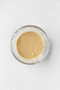 Wet ingredients for making gluten-free coffee cake mixed together in a bowl.