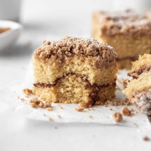 Square hero shot of a square of gluten-free coffee cake with a bite taken out.