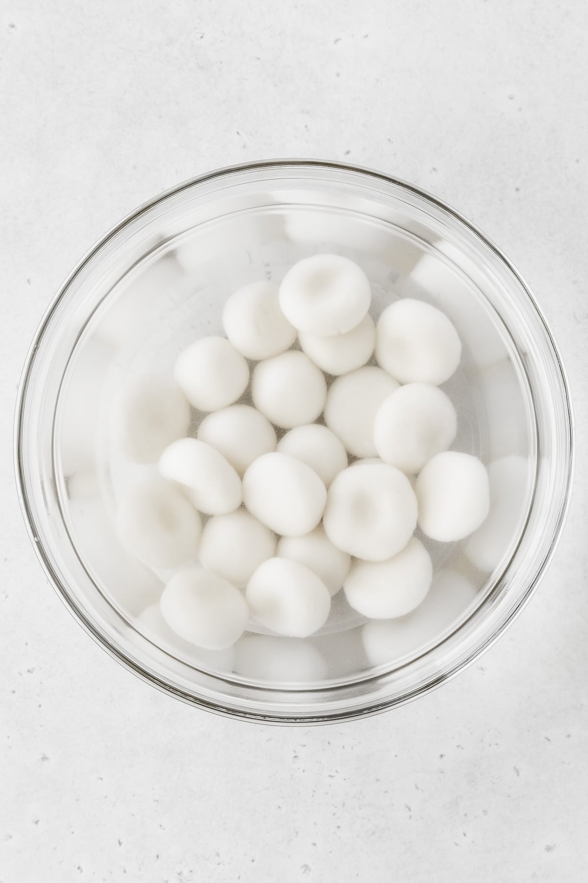 Boiled shiratama cooling in a glass bowl of cold water.