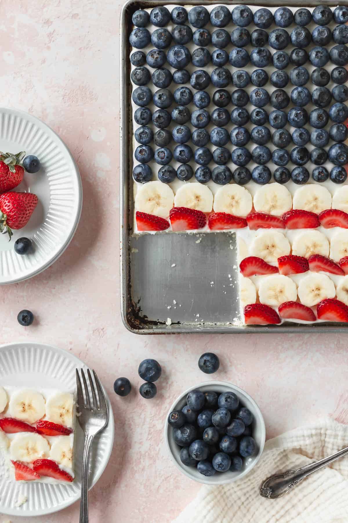 A pan of patriotic flag cookie cake with a slice taken out.