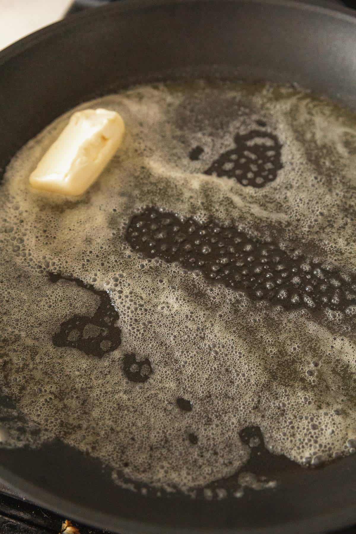 Vegan butter melting in a nonstick pan.