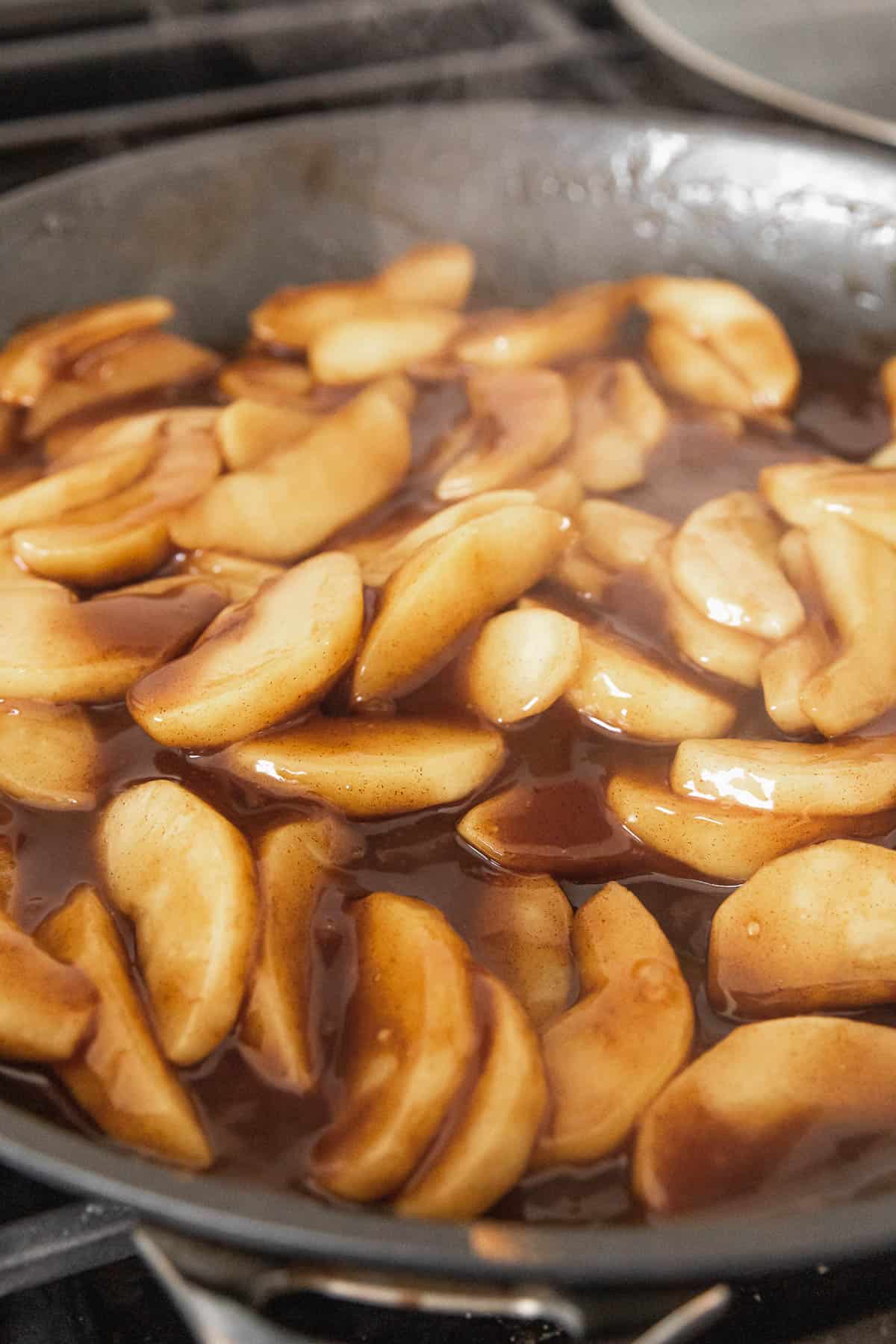 Steamy apple pie filling in a pan.