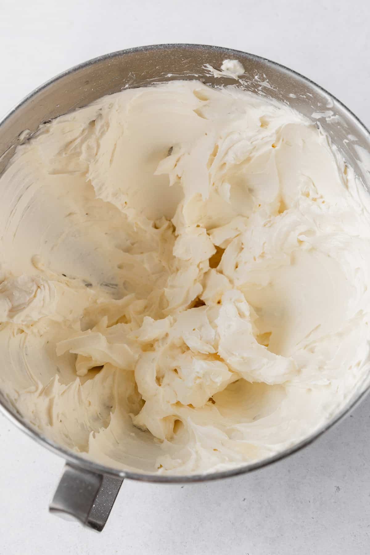 Completed lemon buttercream frosting in the bowl of a stand mixer.