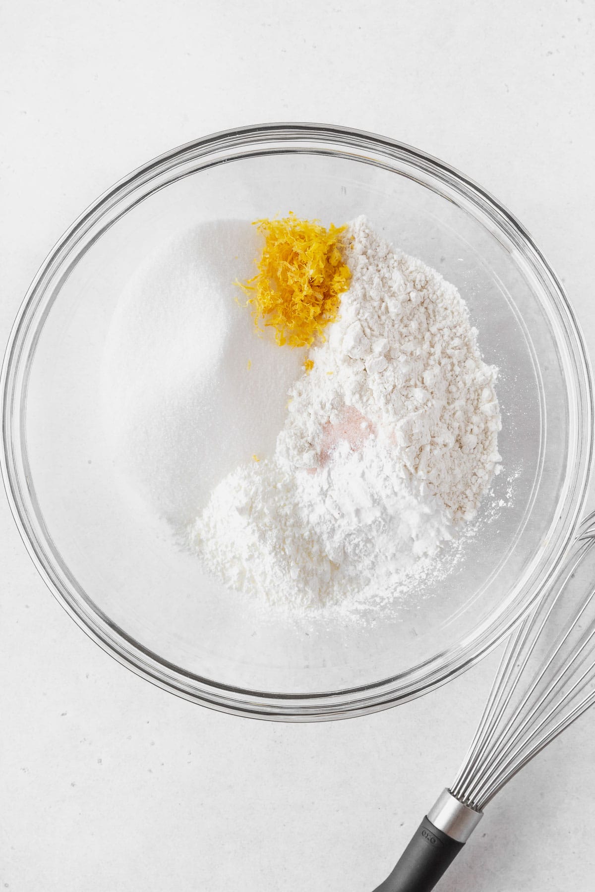 Adding the dry ingredients and lemon zest in a bowl.