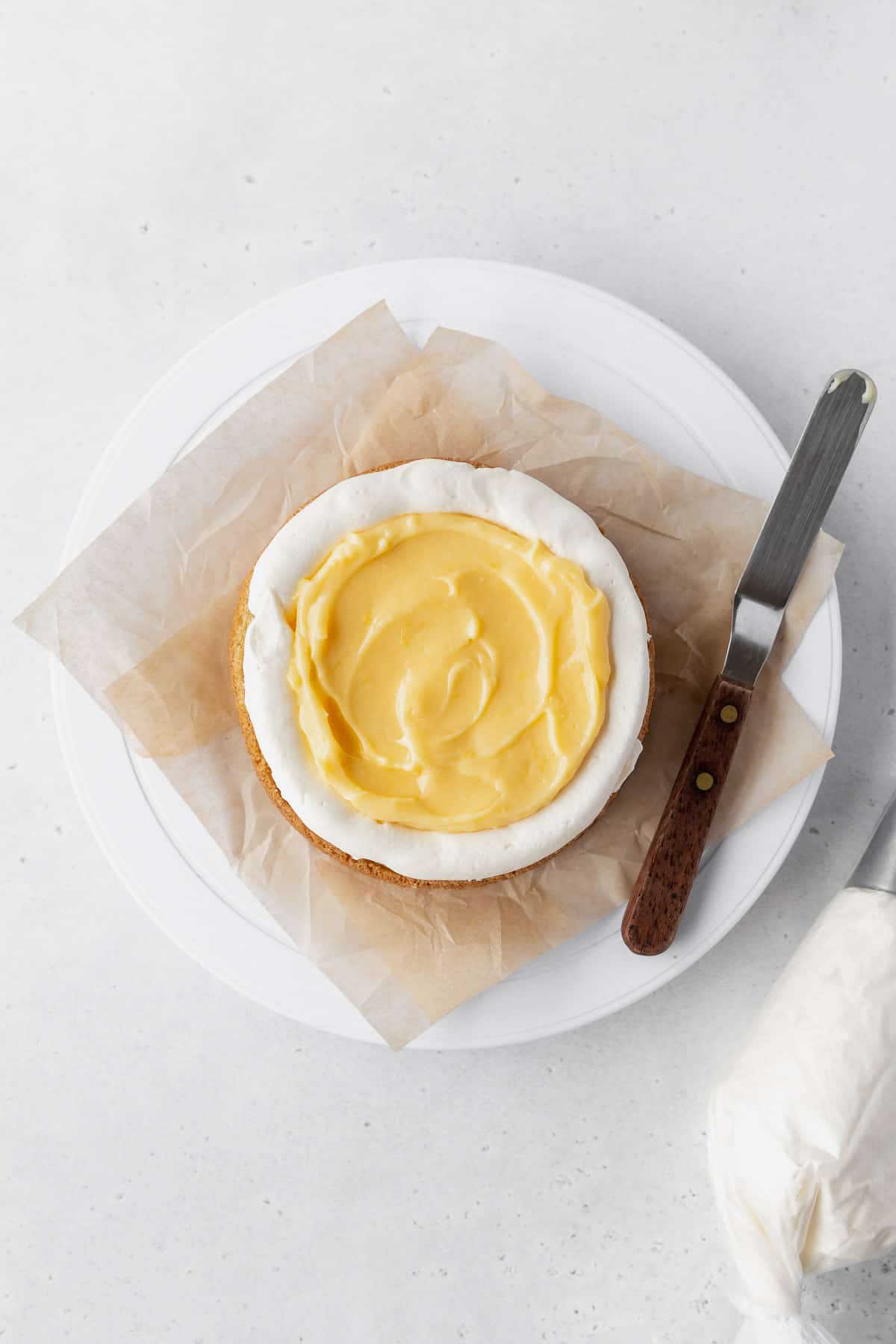 Flooding the center of the cake layer with lemon curd.