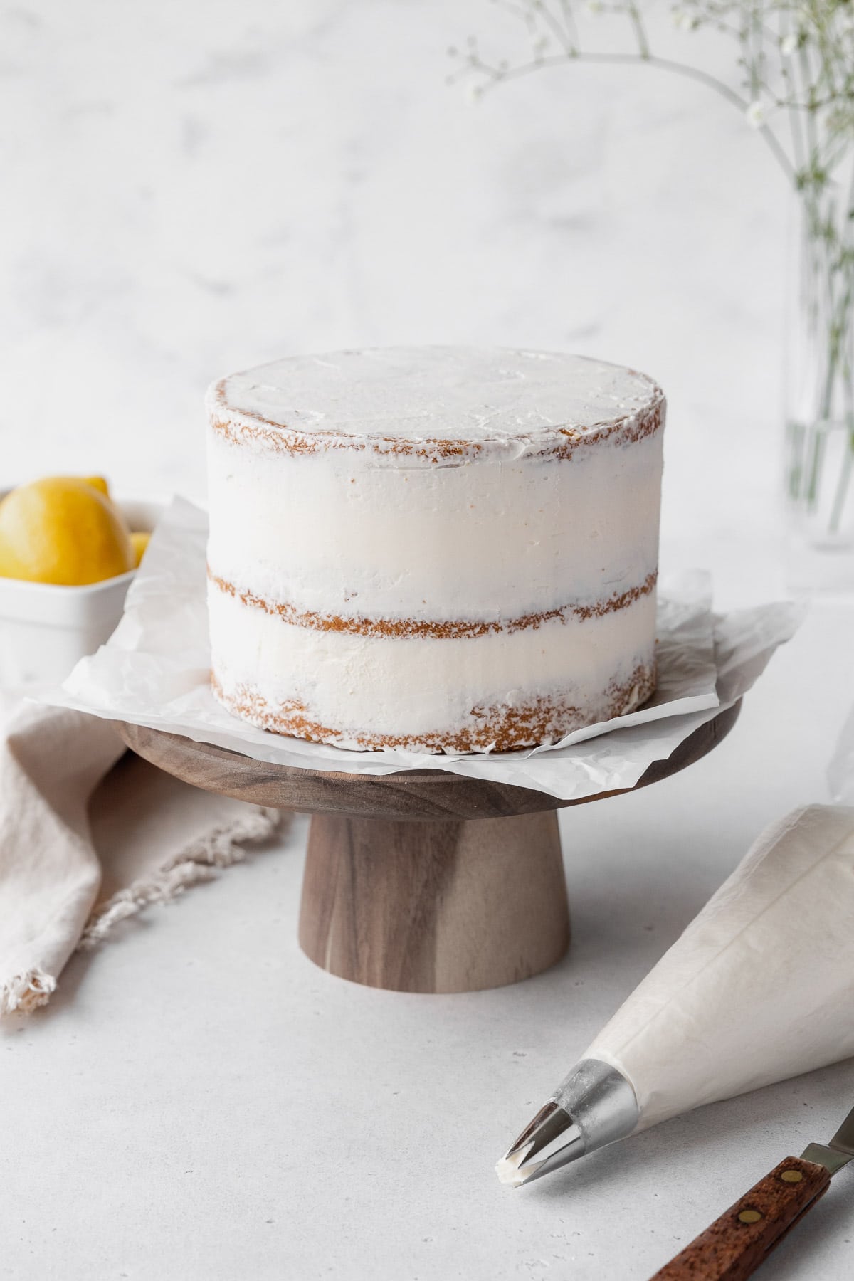 Lemon curd cake after being assembled into 3 layers and given a crumb coat.