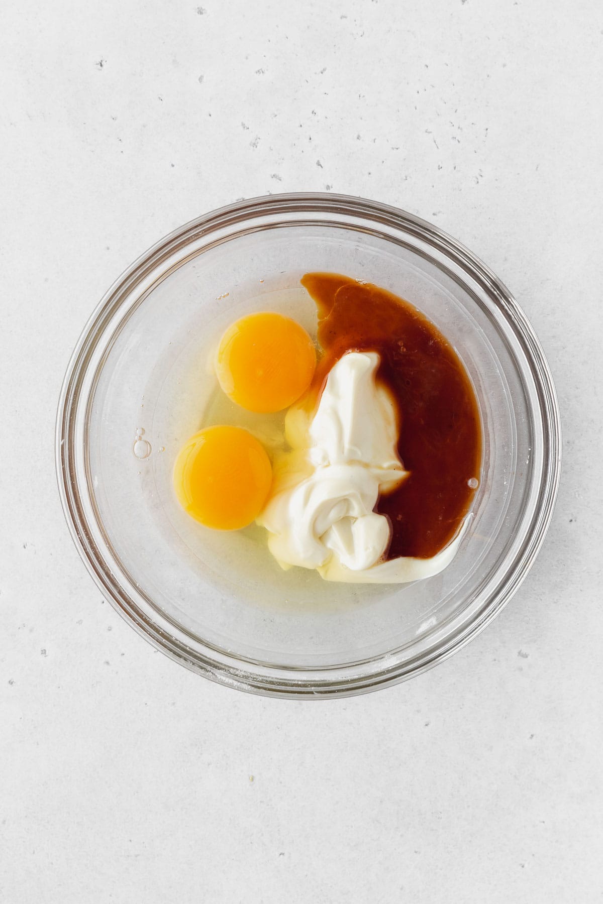 Mayo, eggs, and vanilla in a bowl before whisking.
