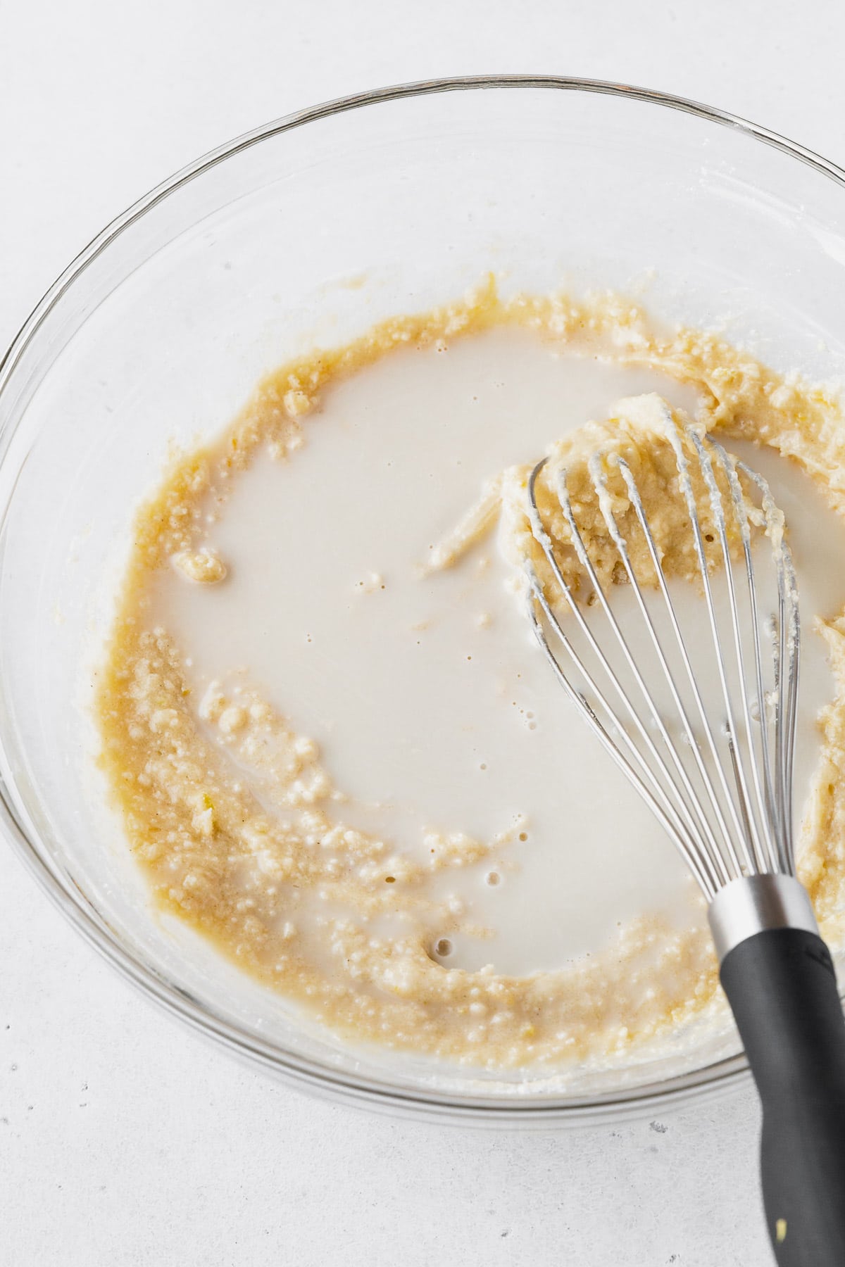 Adding the plant-based milk to the lemon cake batter.