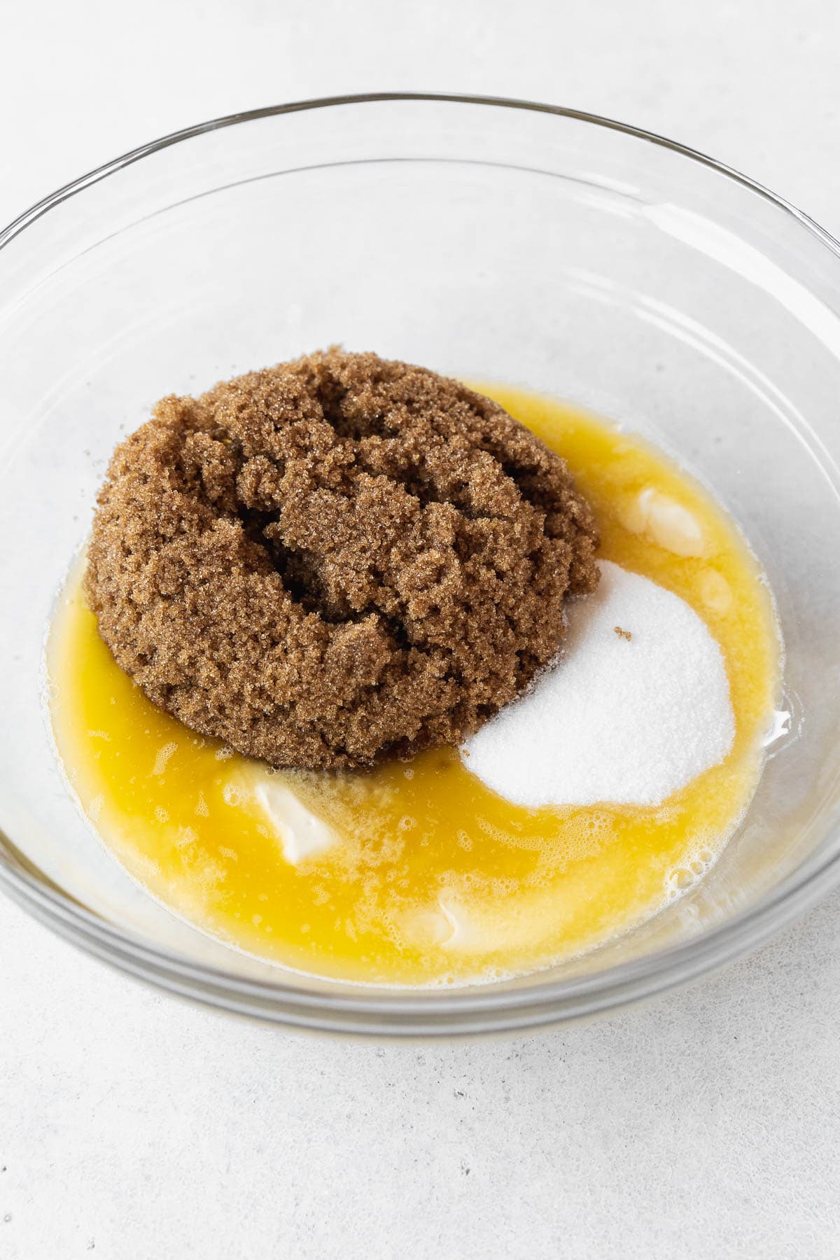 Adding sugars to the melted butter.