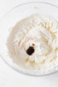 Buttercream frosting with salt and vanilla paste in a glass bowl.