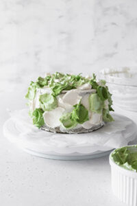 Cake covered in dollops of vanilla and matcha frosting.