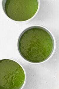 Matcha cake batter in three cake pans.