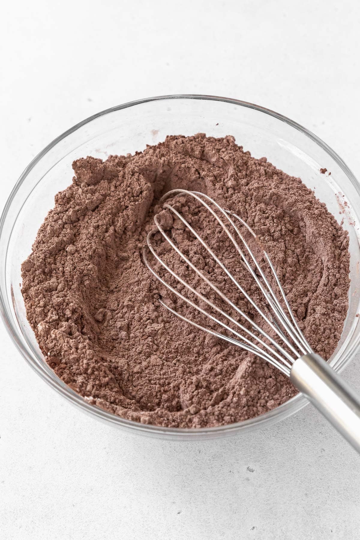 A glass mixing bowl of flour and cocoa.