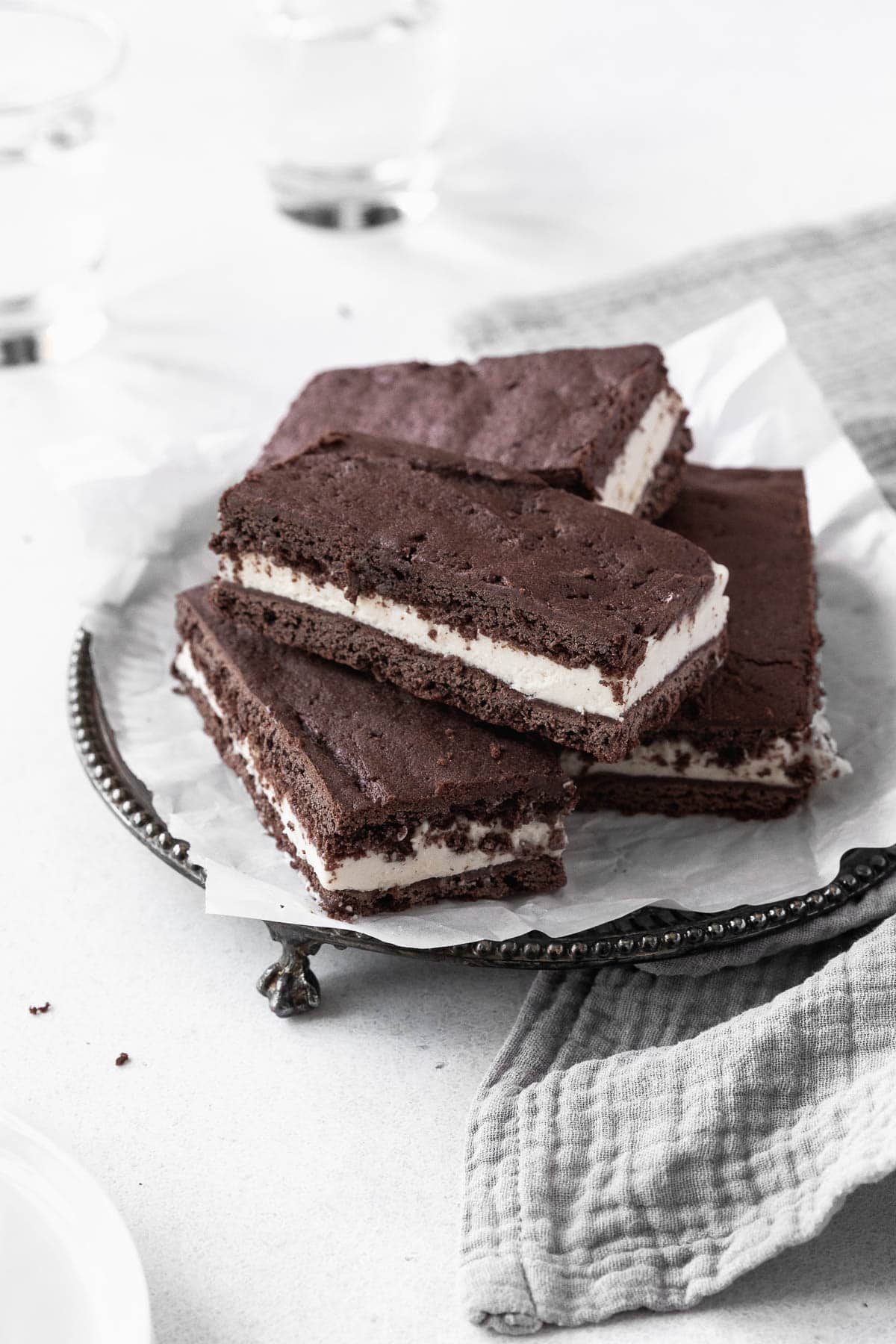 A stack of gluten-free ice-cream sandwich cookies on an antique serving platter.