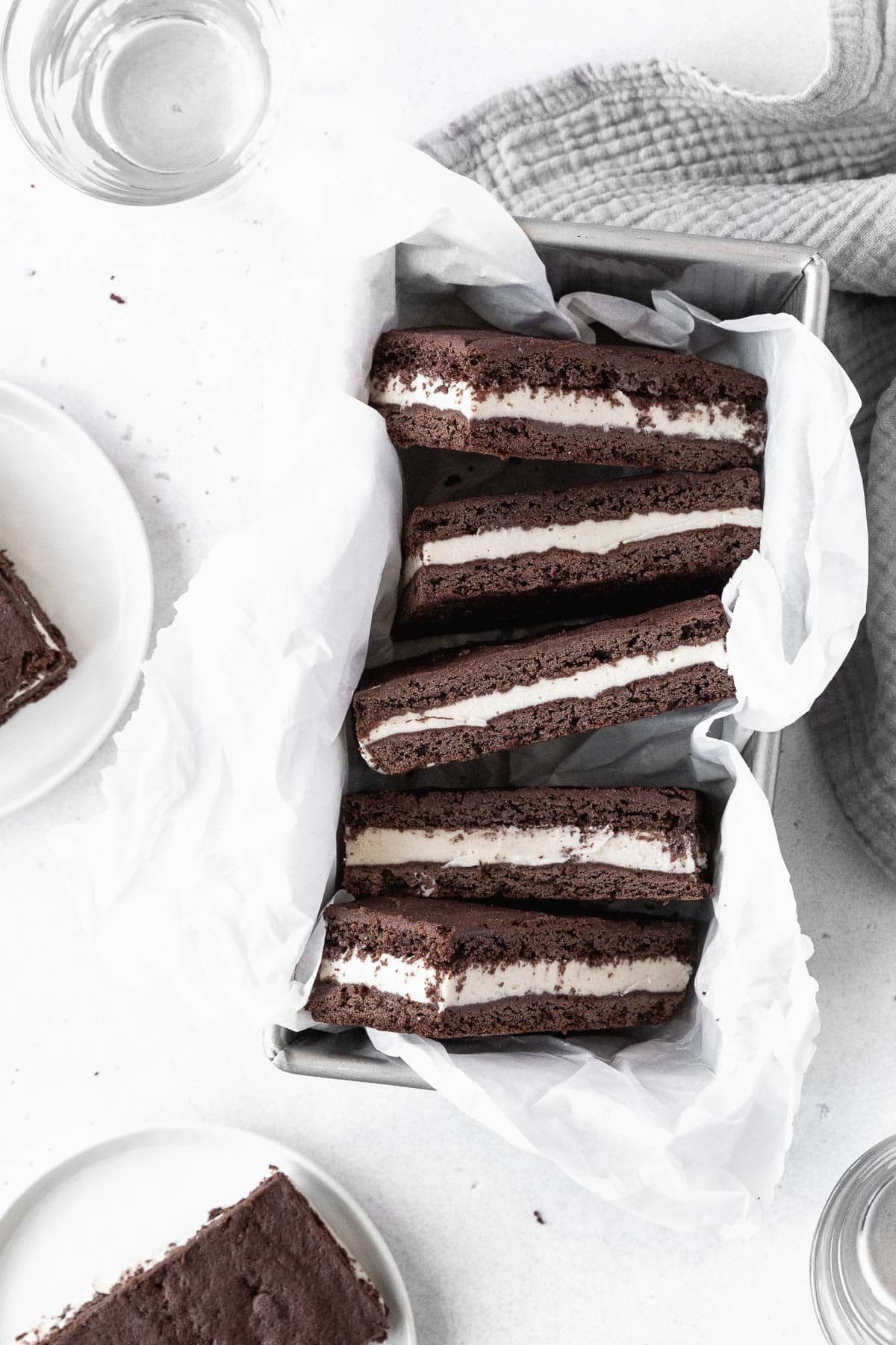 Ice cream sandwich cookies in a parchment paper-lined loaf pan.
