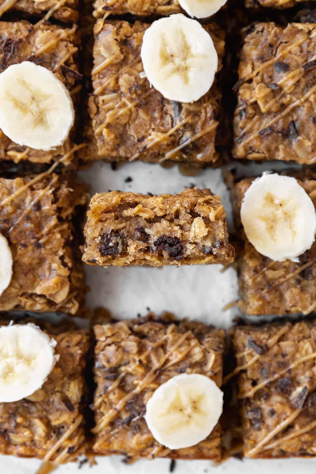 An overhead shot of peanut butter oatmeal bars on the counter with one bar in the center sitting on its side so you can see the inside.
