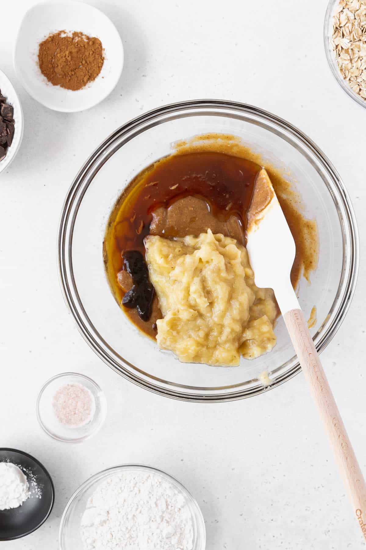 A mixing bowl with peanut butter, maple syrup, vanilla, and mashed bananas.