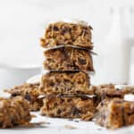 An up-close side shot of a stack of peanut butter banana oatmeal bars with other bars in the background.