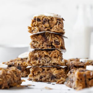 An up-close side shot of a stack of peanut butter banana oatmeal bars with other bars in the background.