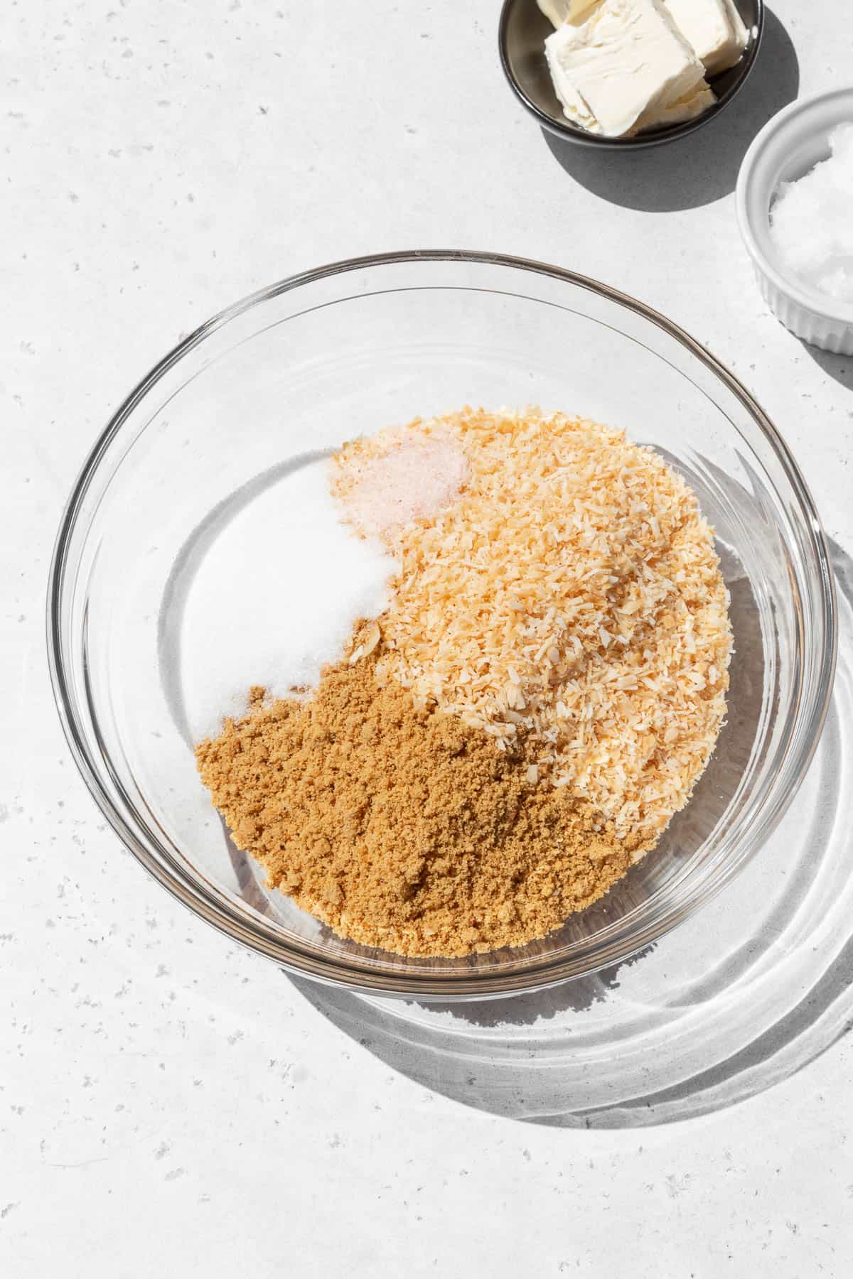 Dry ingredients for making gluten-free coconut graham cracker pie crust in a mixing bowl.