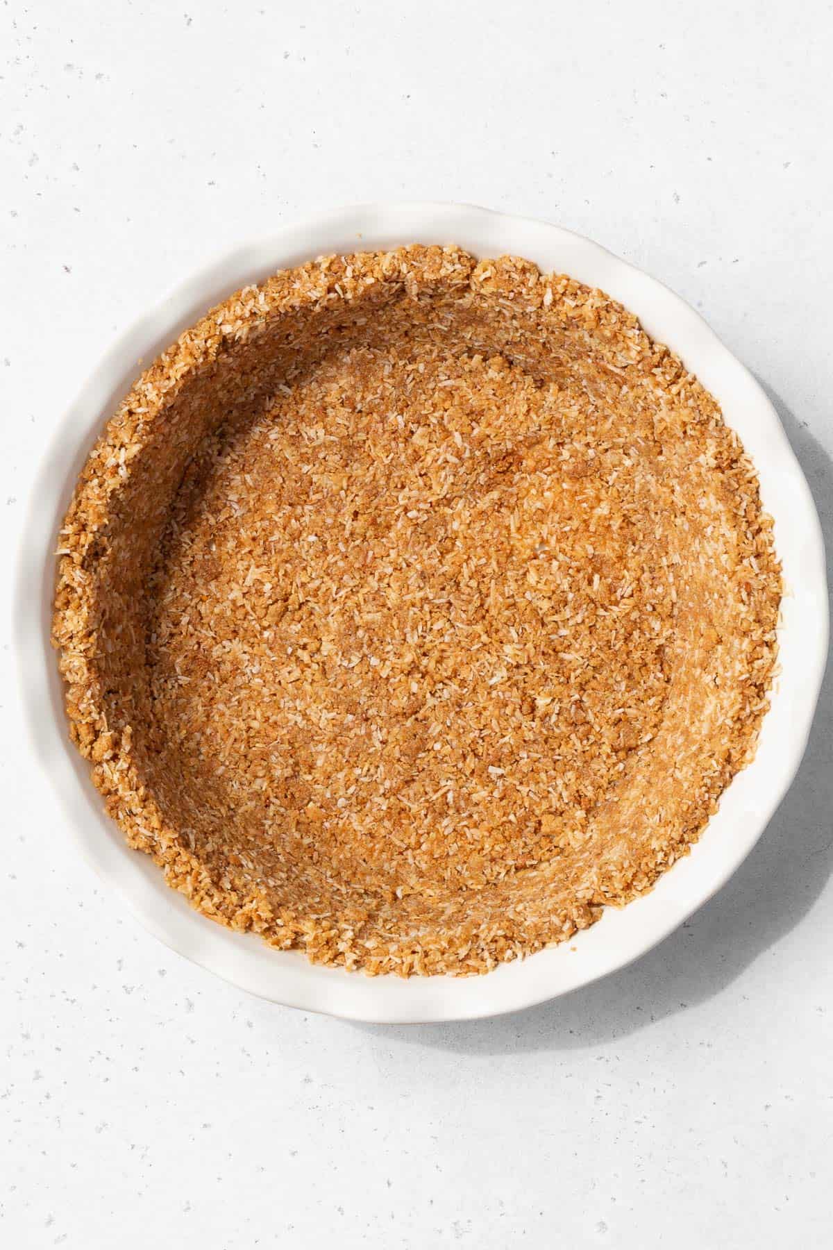 Gluten-free coconut pie crust after pressing into the pie pan.