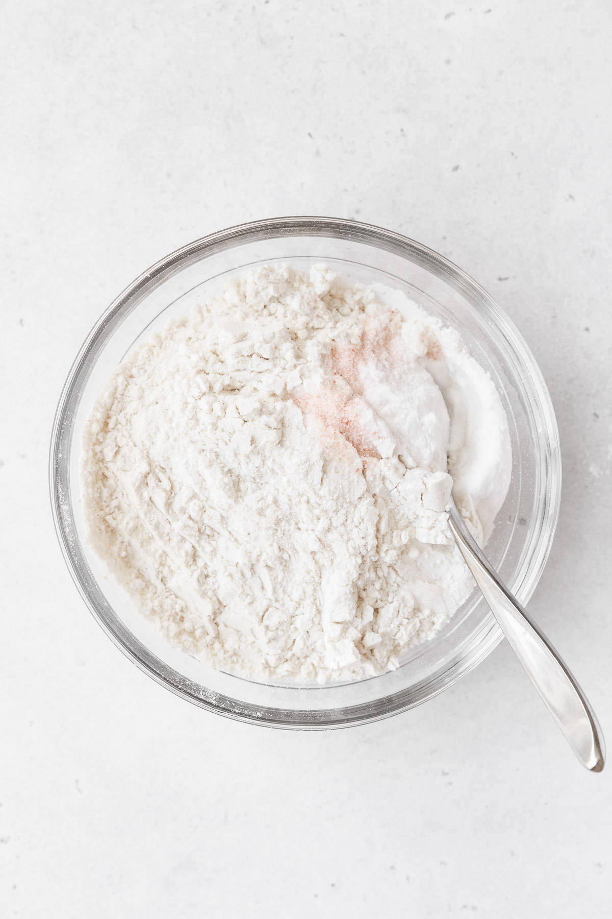 Flour, salt, and baking soda in a glass mixing bowl. 