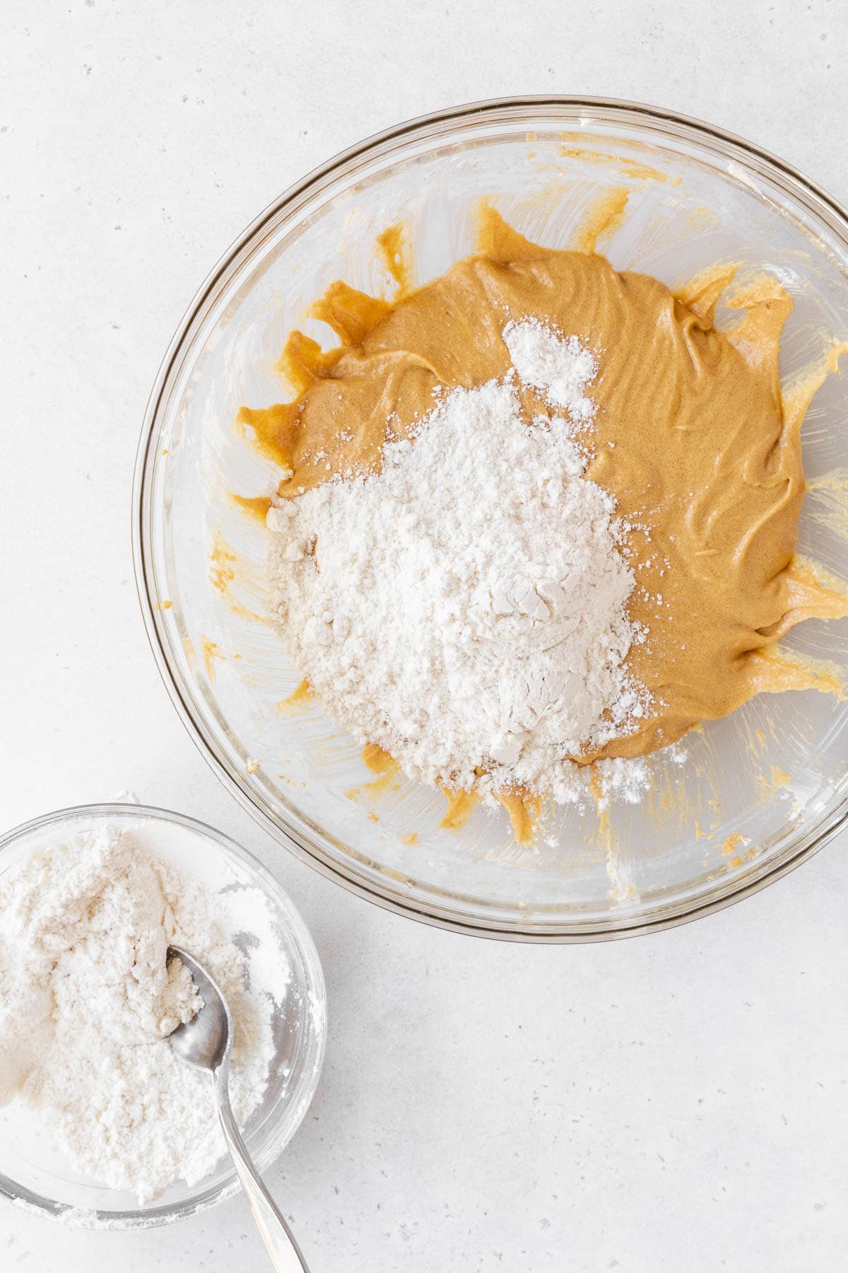 Adding the flour mixture to the peanut butter mixture in the mixing bowl. 