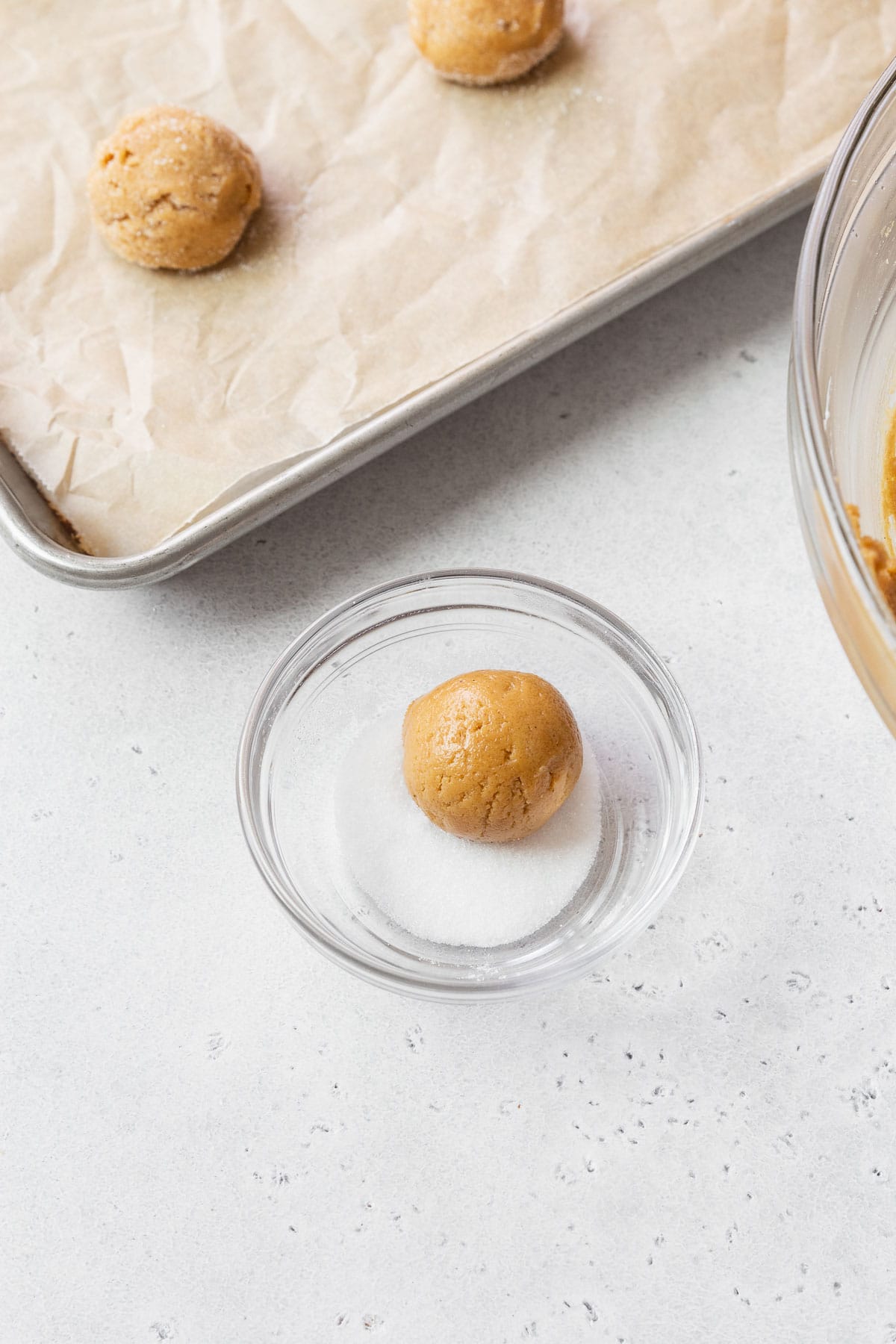 A small scoop of peanut butter in a dish of sugar. 