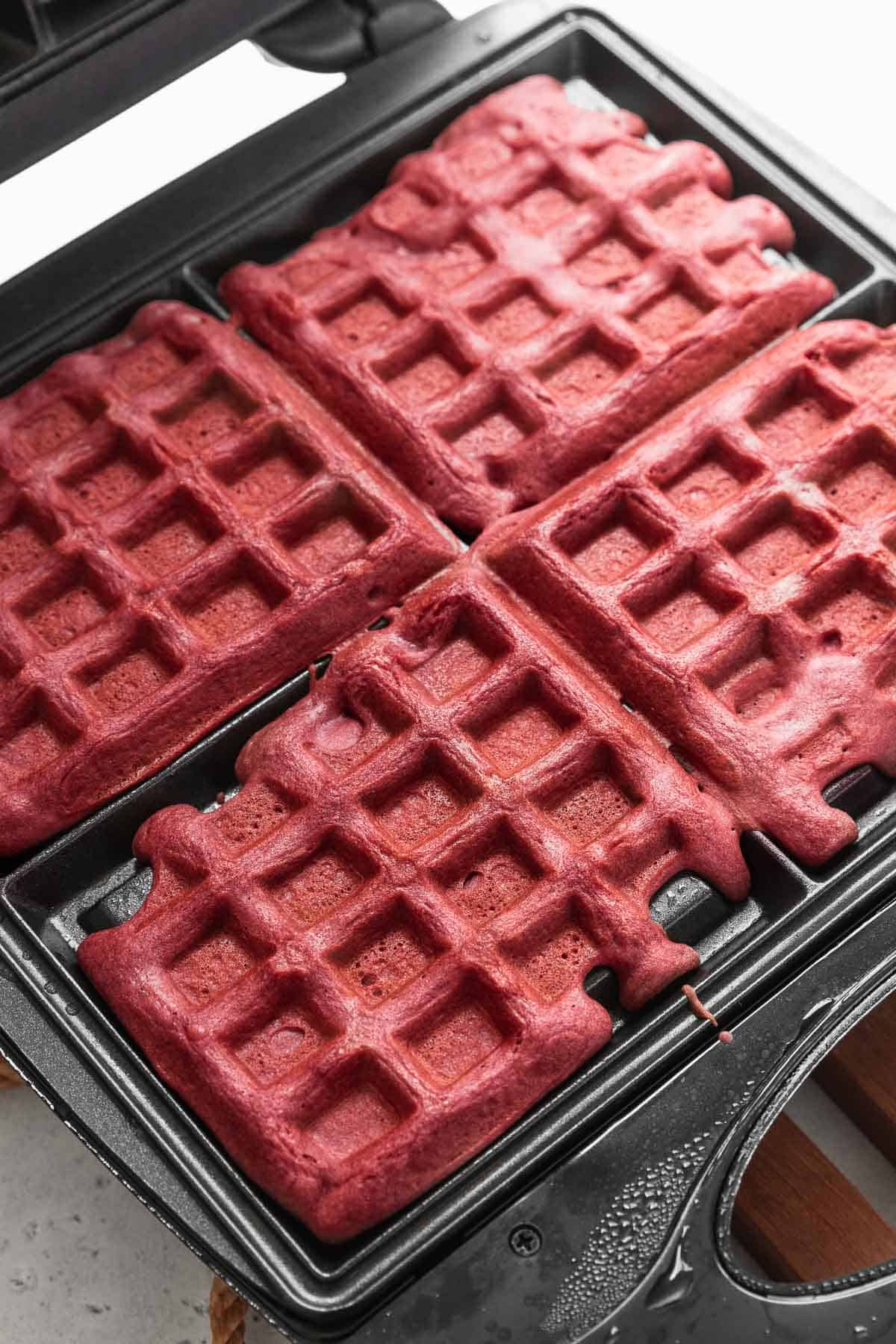 Baked red velvet waffles still in the waffle maker.