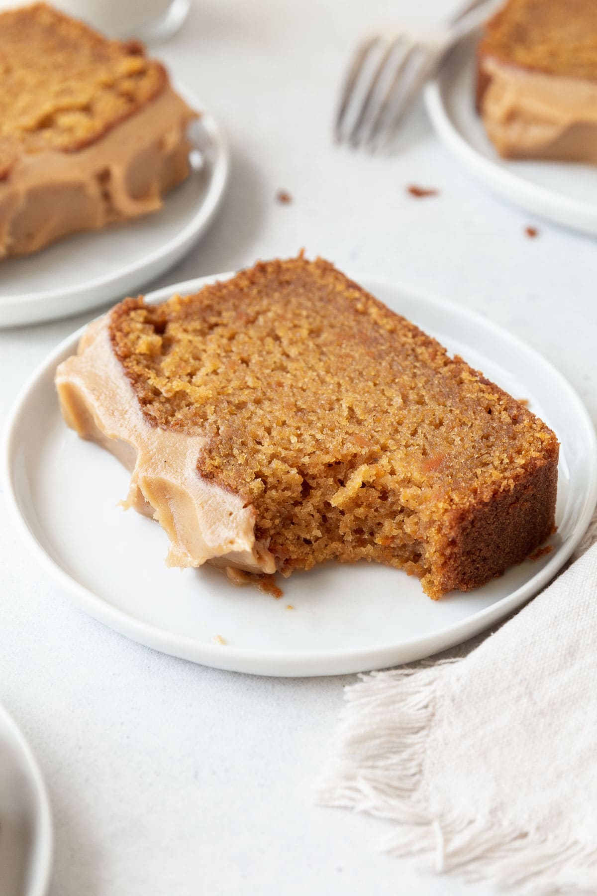 A bitten slice of gluten-free sweet potato cake on a dessert plate.