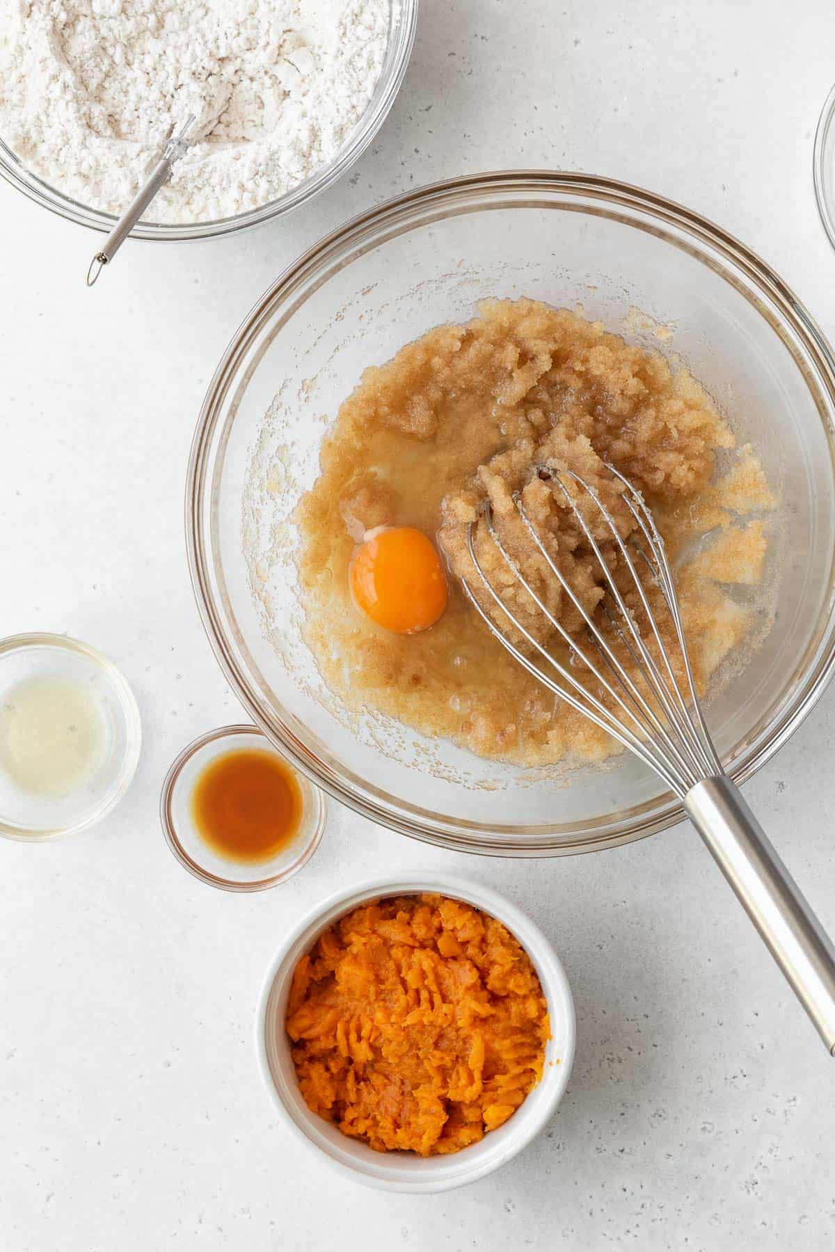 Whisking an egg into the oil and sugar mixture.