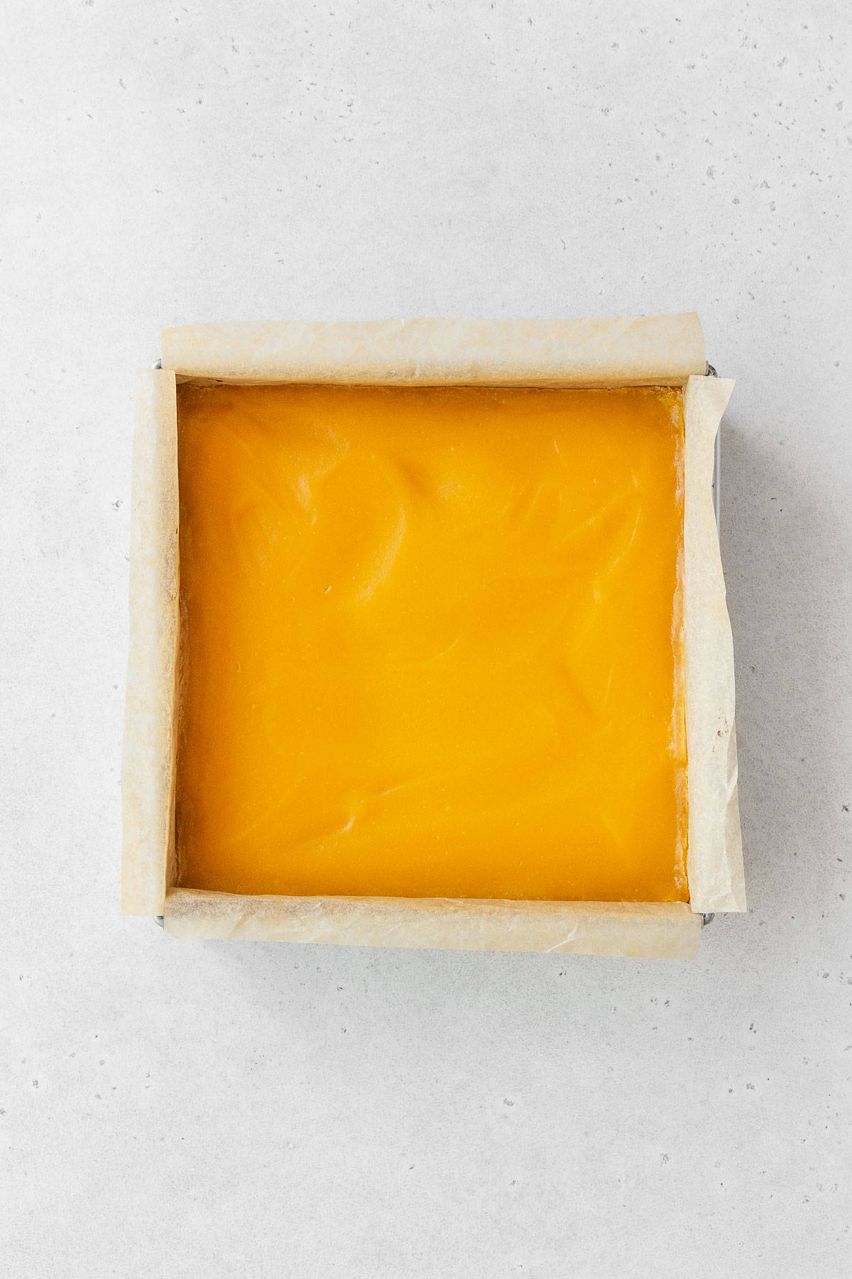 A pan of baked dairy-free lemon bars before dusting with powdered sugar.