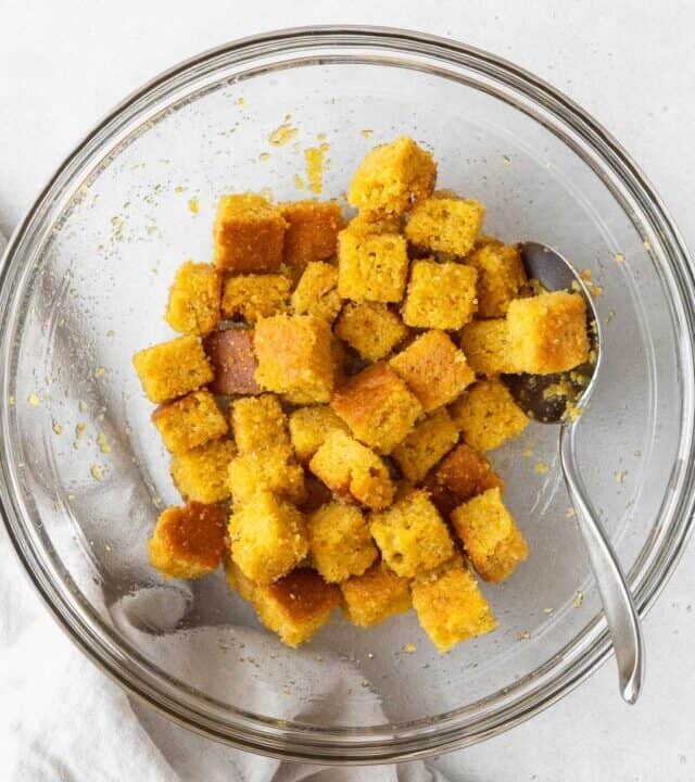 A large mixing bowl of the corn bread croutons before baking.