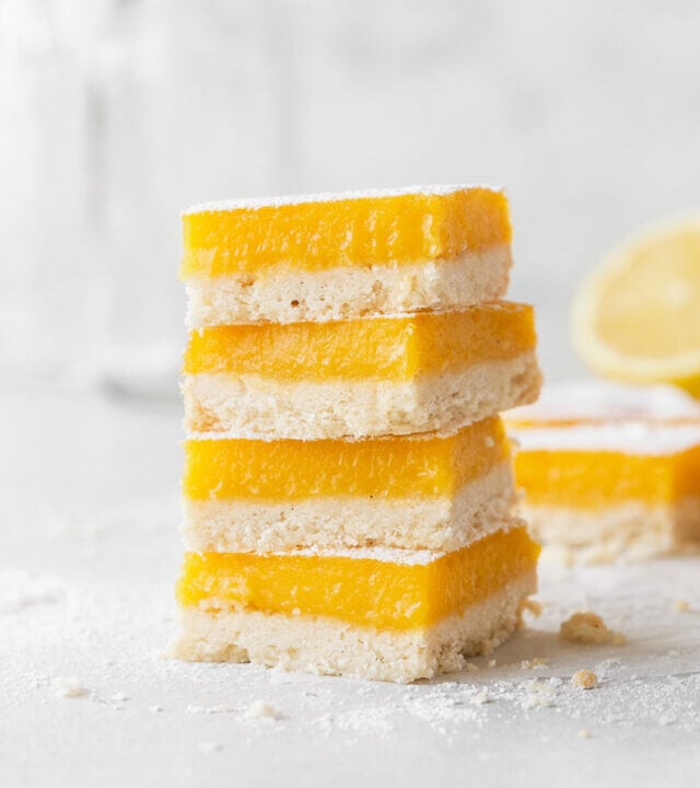 A side shot of a stack of dairy free lemon bars on the counter.
