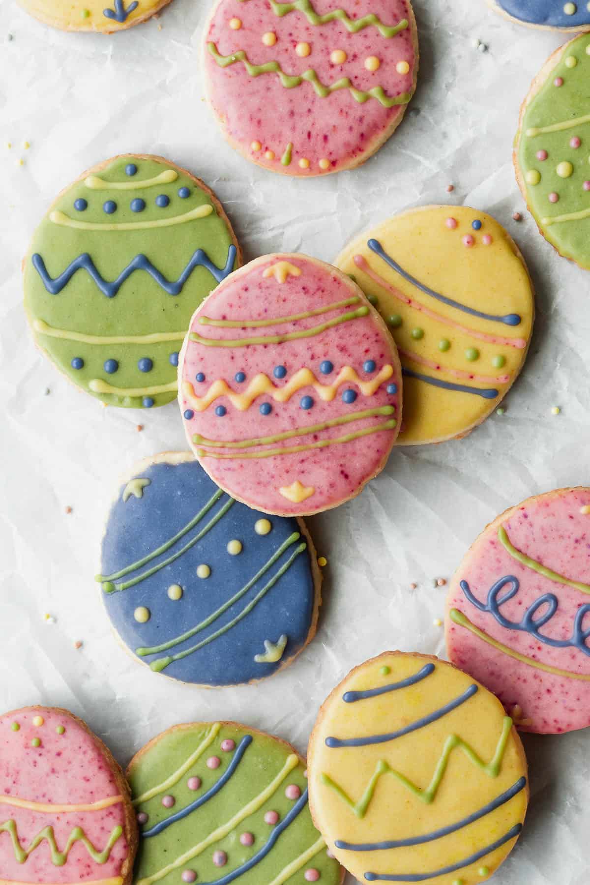 Overhead shot of decorated Easter cookies on a white surface.
