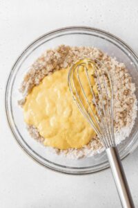 A mixing bowl of the wet ingredients added into the dry ingredients.