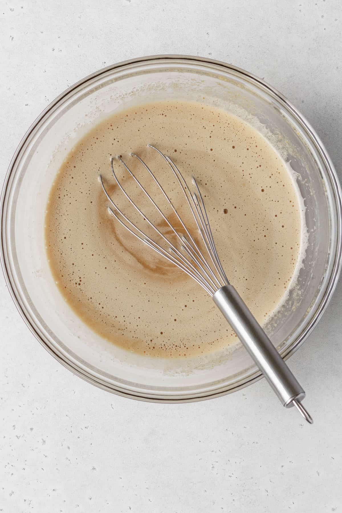 Wet ingredients whisked together in a large glass bowl.