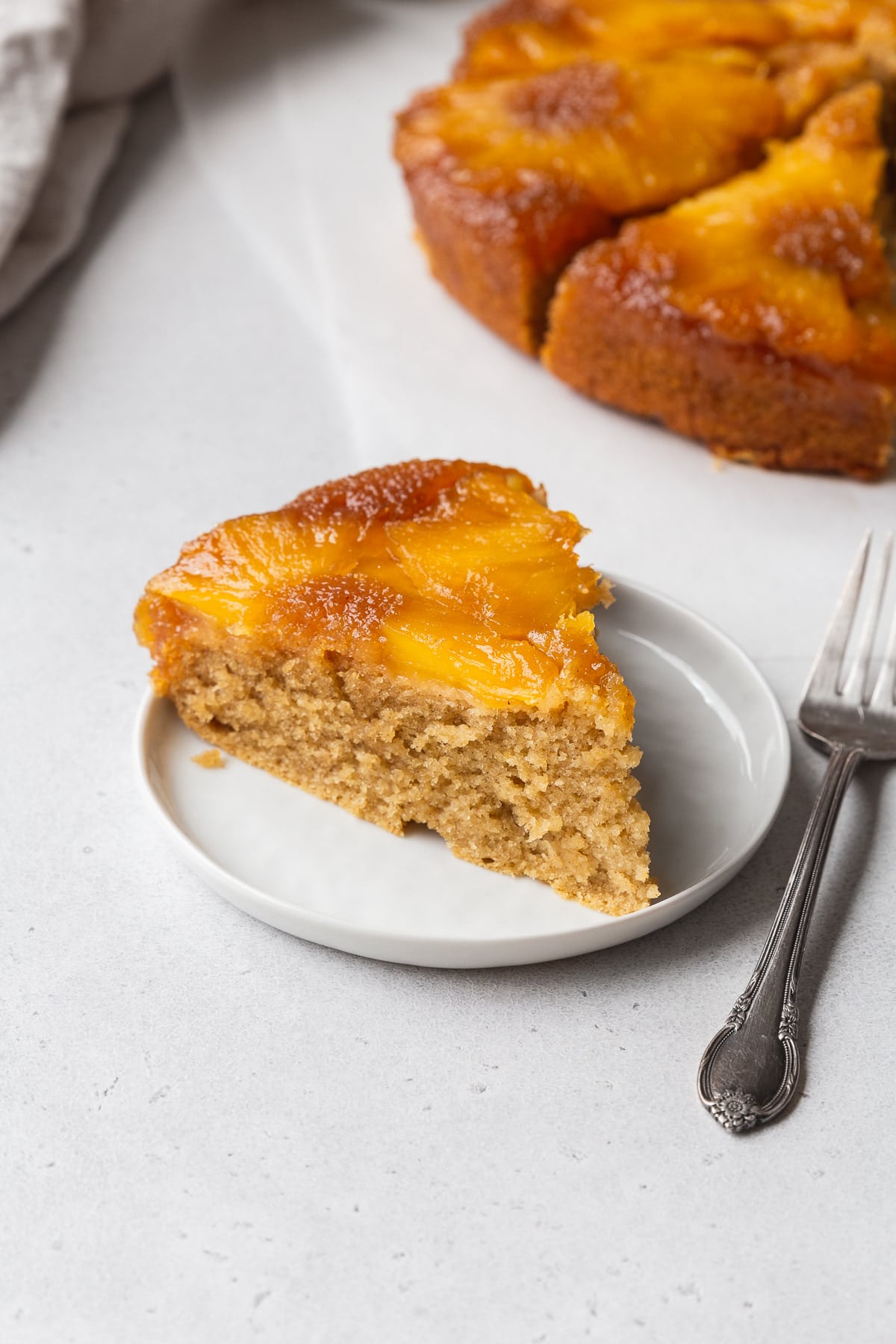 An up-close shot of a slice of gluten-free upside down pineapple cake on a dessert plate.